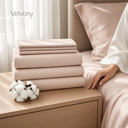 Complete peach blush cotton sateen bedding set on a bed: sheets, duvet cover and pillowcases, available in Queen and King
